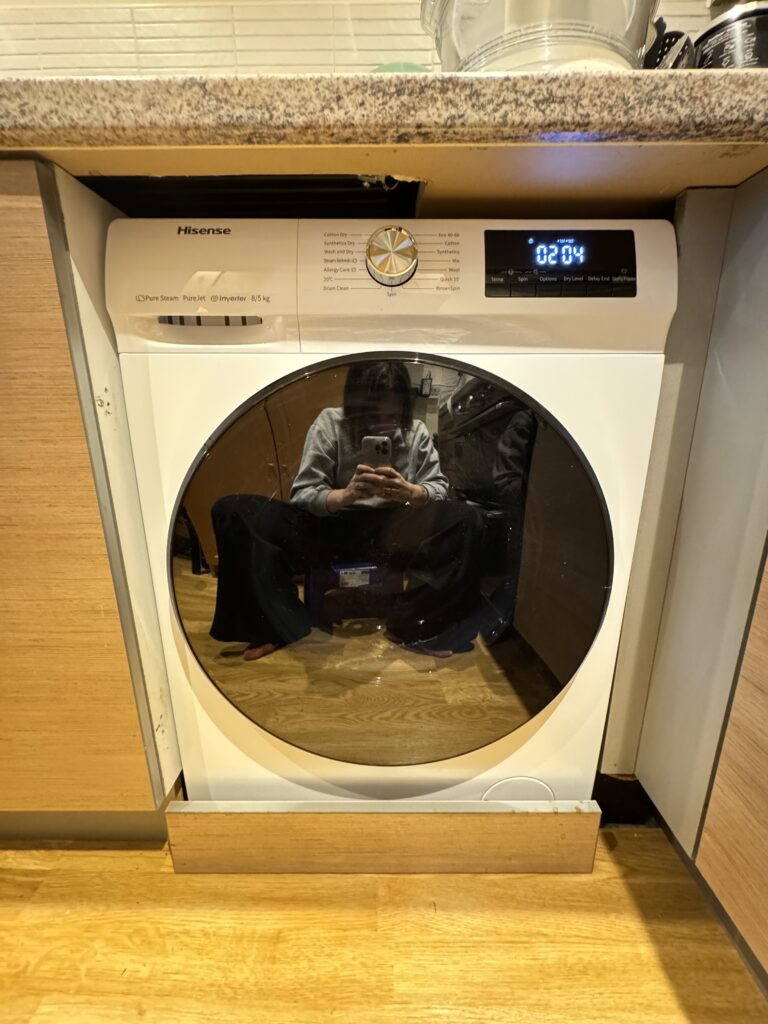 A large washing machine with person taking a picture in it 