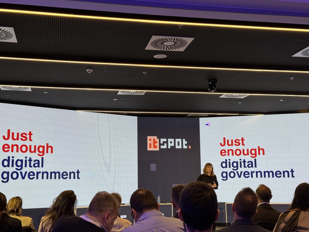 Slide shows a woman speaking in front of a large screen saying just enough digital government 