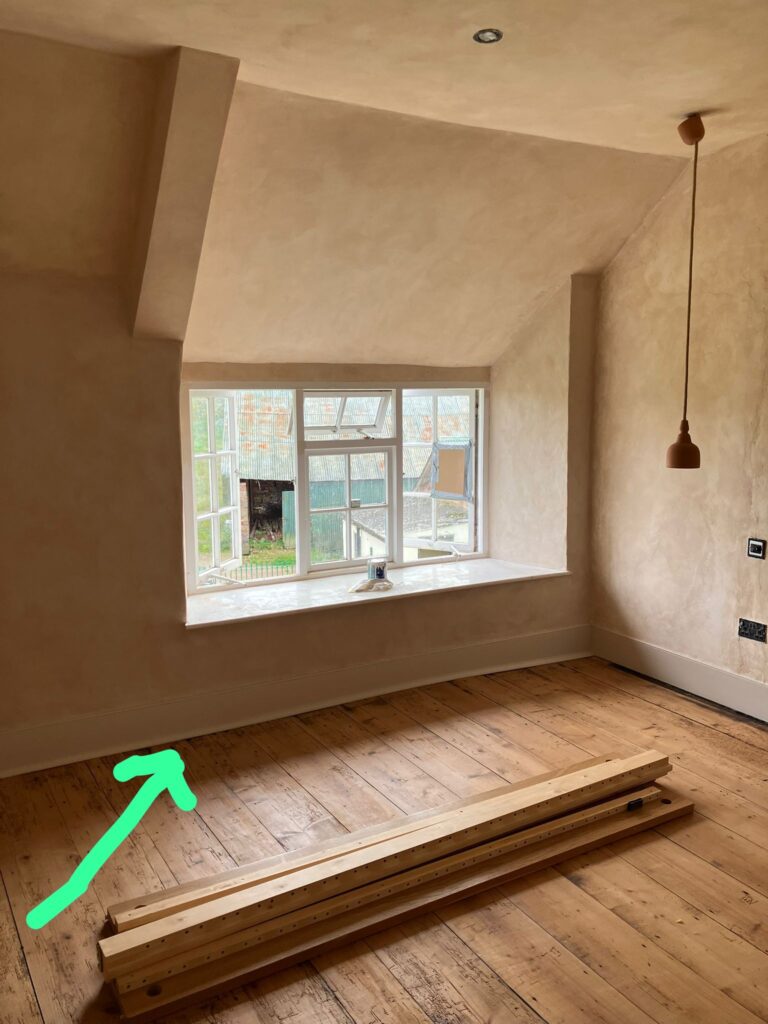 A beige room with square windows looking out onto a barn